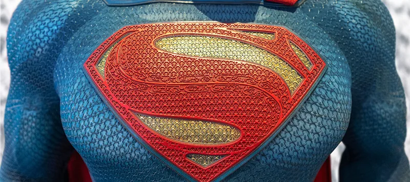 Primer plano del símbolo de Superman en el pecho del traje.