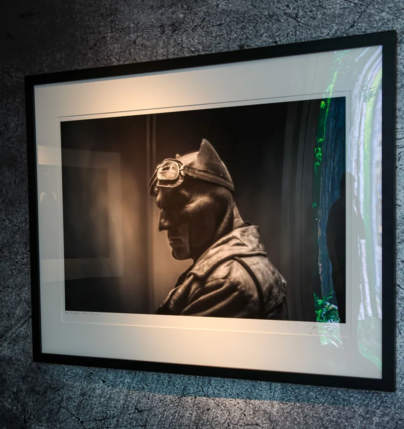 Fotografía enmarcada en blanco y negro de Knightmare Batman con gafas de aviador, en vitrina