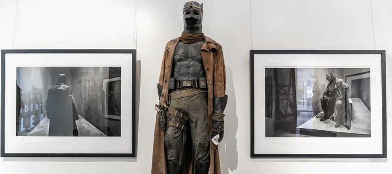 Disfraz de Knightmare Batman con gabardina entre dos fotografías enmarcadas en blanco y negro